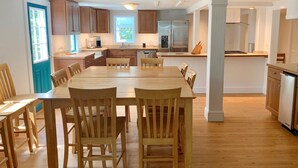 Une cuisine spacieuse avec des meubles en bois, un grand îlot central et des appareils électroménagers modernes.