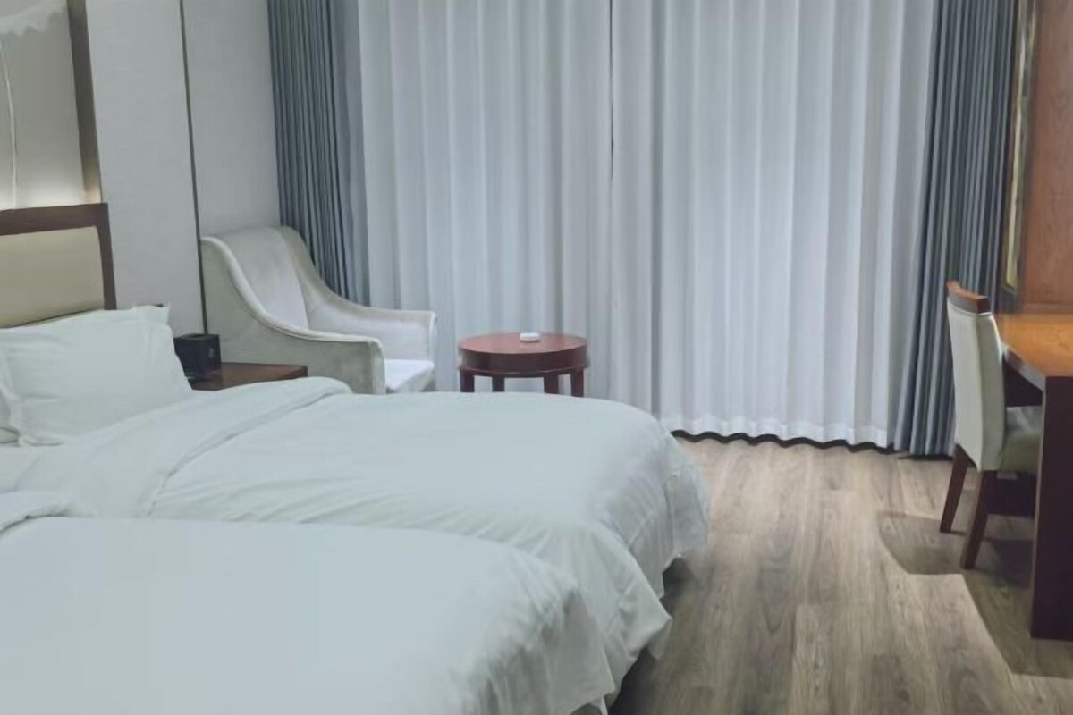 Una habitación de hotel con una cama grande, un escritorio, una silla y una mesita.