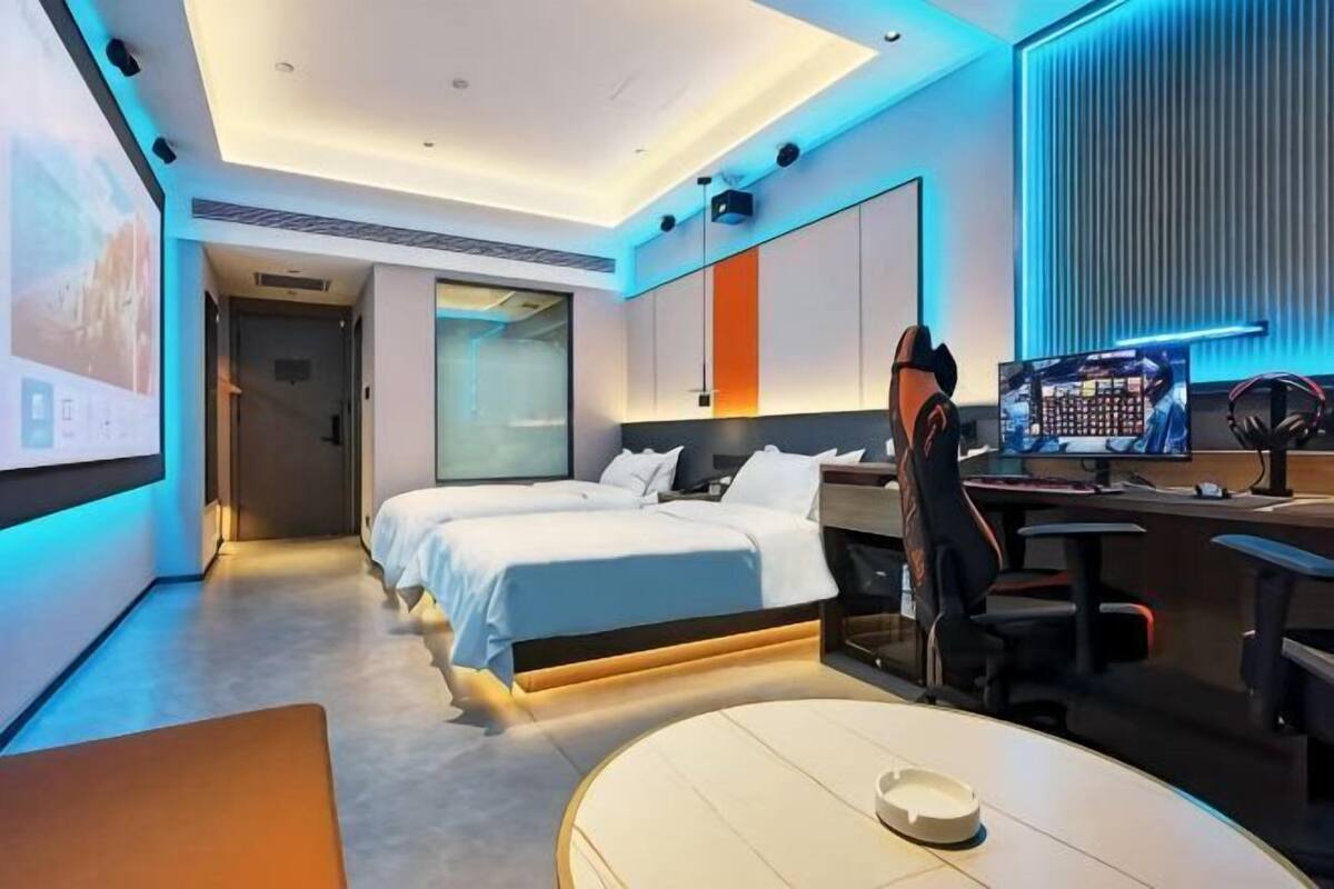 Una habitación de hotel moderna con cama, escritorio y ordenador.
