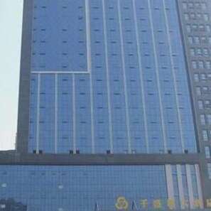Un edificio de gran altura con fachada azul y numerosas ventanas.