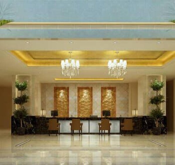 Un área de recepción con mostrador de mármol, dos candelabros y plantas en macetas.