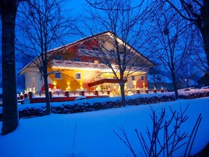 A large, brightly lit chalet with a snow-covered roof and a well-lit entrance. - Tunzendorferwirt (Michaelerberg-Pruggern)