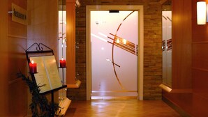 Un couloir d’hôtel avec un comptoir de réception, un présentoir à menus décoré de bougies et une vue sur le hall d’entrée.