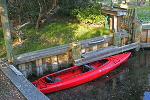 A red kayak docked at a wooden pier.