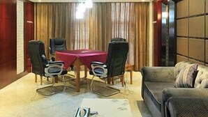 Una sala de conferencias con una mesa roja, cuatro sillas y un sofá.