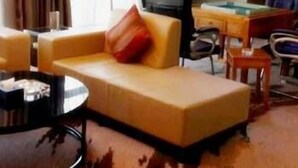 Una habitación de hotel con sofá, mesa de billar, televisor y escritorio.