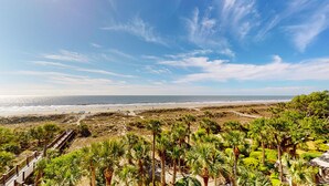 Ein Strand mit Palmen und blauem Himmel.