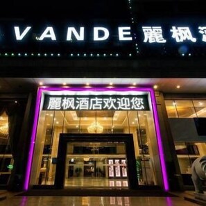 L’entrée d’un hôtel, avec une enseigne lumineuse et un message d’accueil en chinois.