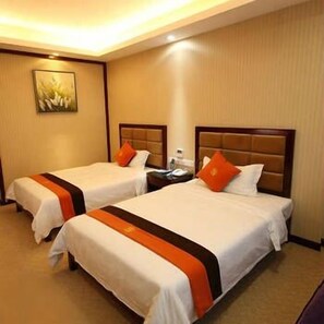 Una habitación de hotel con dos camas, cada una con cabecero, mesita de noche y un cuadro en la pared.