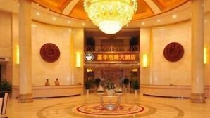 Un hall d’entrée spacieux agrémenté d’une fontaine centrale, d’un lustre et d’un comptoir d’accueil.