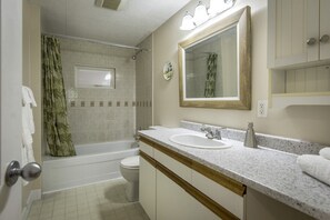 Ein Badezimmer mit Badewanne, Toilette, Waschbecken und Spiegel.