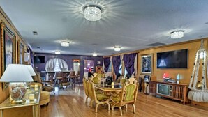 A dining area with a round table and chairs, a television, and a chandelier. - Presley's Penthouse 2BR Branson Resort Condo (Branson)