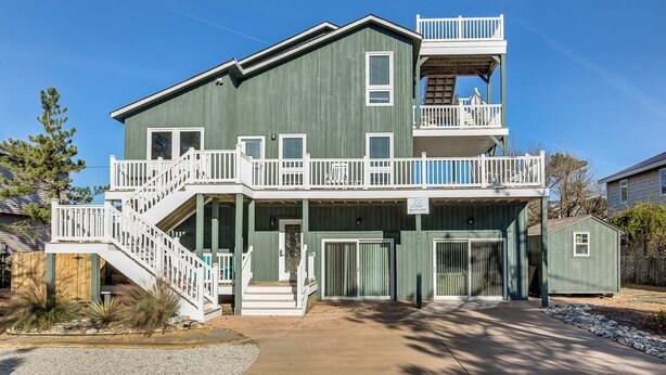 A two-story house with a balcony on the upper level, a front porch, and a garage.