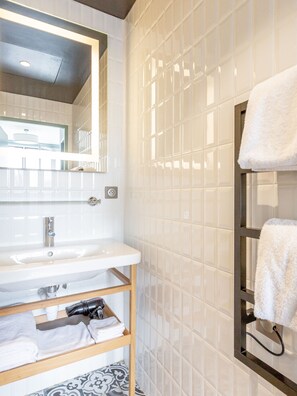 A bathroom with a white sink, mirror, and tiled walls. - Edgar Suites Expo Paris Porte de Versailles (Paris)