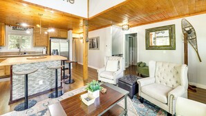 A spacious living area with a wooden ceiling, a kitchen with a stone backsplash, and a bar area. - Remodeled Crestline Retreat: Walk to Lake Gregory! (Crestline)
