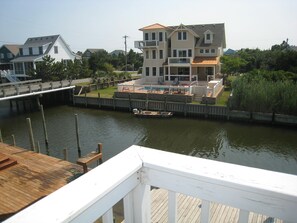 A waterfront property with a dock, a pool, and a multi-story house.