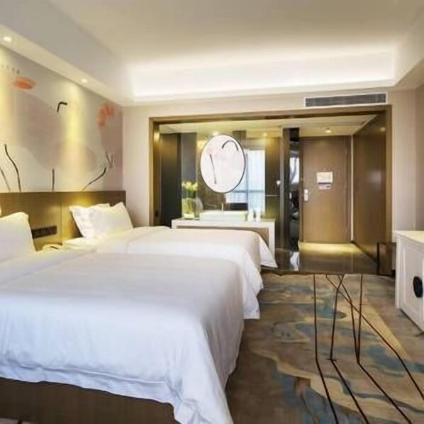 A hotel room with two beds, a large mirror, a wooden headboard, and a patterned carpet. - Mehood Theater Hotel (Guangzhou)