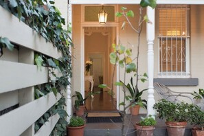 A house entrance with a wooden fence, potted plants, a bench, and a hanging lantern. - Gorgeous central Subiaco cottage - walk to Kings Park, cafes, restaurants, train (Subiaco)