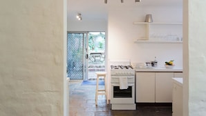 A kitchen with a gas stove, oven, and white cabinets.