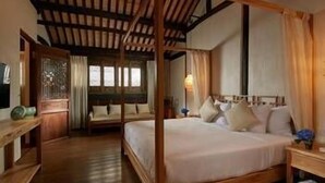 A traditional wooden four-poster bed with a canopy, a wooden nightstand, and a bedside table with a lamp. - Kaiyuan Hotel · Seabirds (Hangzhou)