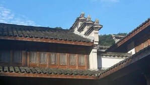 A traditional building with wooden doors and a tiled roof. - Kaiyuan Hotel · Seabirds (Hangzhou)