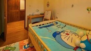 A child's bedroom with a bed, a small desk, and a wall clock. - Kaiyuan Hotel · Seabirds (Hangzhou)
