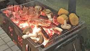 A barbecue grill with various meats and vegetables being cooked. - Pension Smile Again (Shimoda)