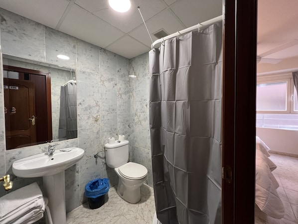 A bathroom with a sink, toilet, and shower curtain.