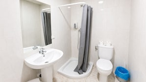 A modern bathroom with a sink, toilet, shower, and a mirror. - Hostal La Embajada (Talavera de la Reina)