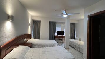 Habitación triple | Escritorio y ropa de cama