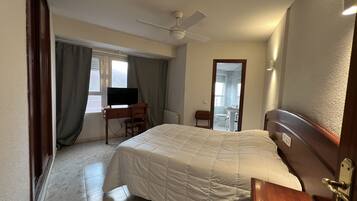 Habitación doble | Escritorio y ropa de cama