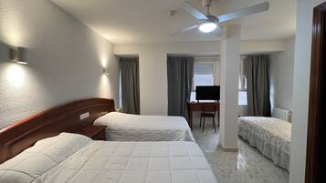 Habitación triple | Escritorio y ropa de cama