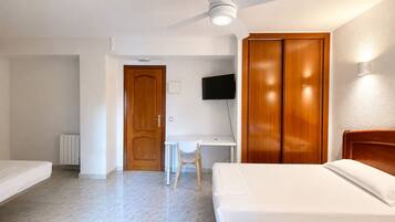 Habitación triple | Escritorio y ropa de cama