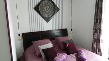 A neatly made bed with multiple pillows and a decorative wall hanging.