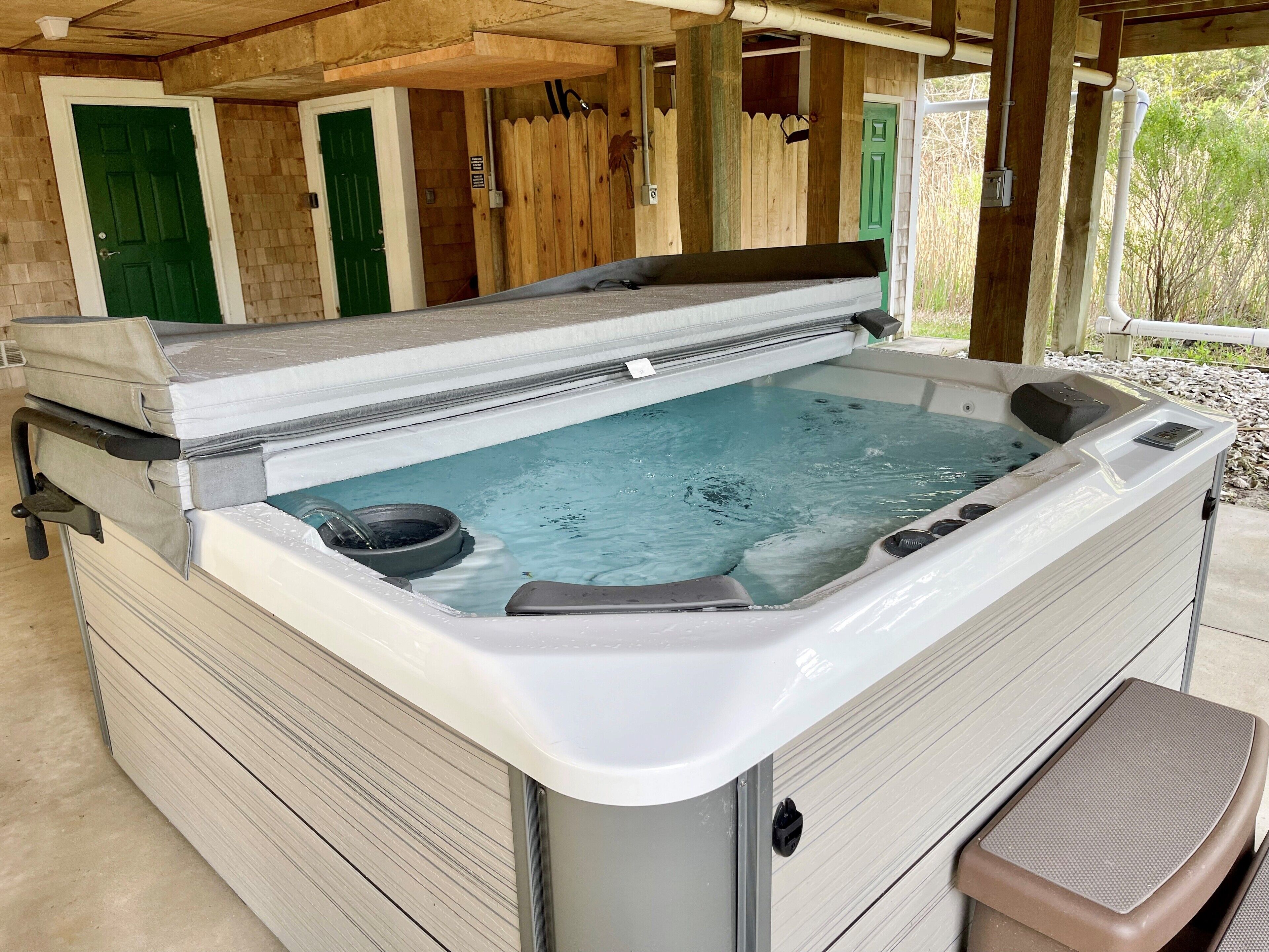 A hot tub with a wooden deck and a covered area.
