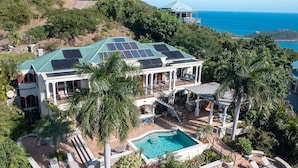 A large house with a swimming pool, solar panels, and a view of the ocean. - La Bella Vita: Full AC! Pool! Sunset Views All Year! (St. John)