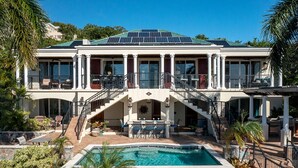 A large, two-story house with a swimming pool, solar panels, and a covered patio area. - La Bella Vita: Full AC! Pool! Sunset Views All Year! (St. John)
