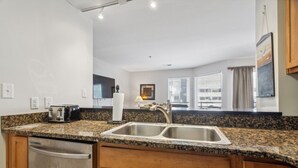 Una cocina moderna con encimeras de granito, electrodomésticos de acero inoxidable y armarios de madera.