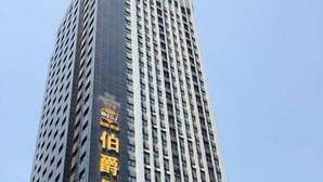 A tall building with a sign indicating it is a hotel. - Bo Jue Holiday Inn (Hefei)