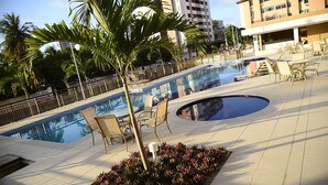 A pool area with lounge chairs, palm trees, and a sign reading "LAVA JATO". - Para 9 Pessoas ao Lado Shopping Rio Mar (Fortaleza)