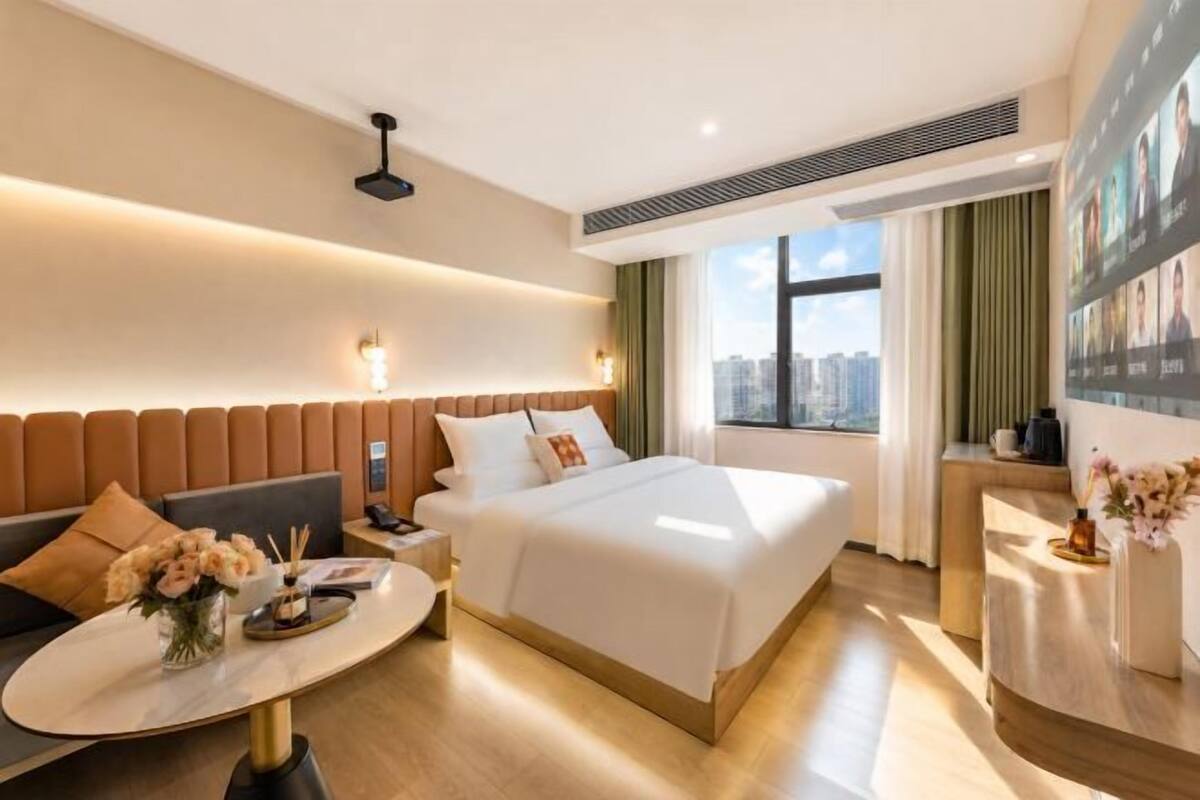 Une chambre d’hôtel avec un lit, un canapé, un bureau et une vue sur la ville.