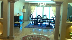 A dining area with a chandelier, a round table, and chairs.