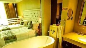 A modern bathroom with a freestanding bathtub, a large mirror, and a vanity with a sink. - Heyuan City Holiday Hotel (Heyuan)