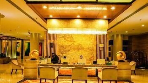 A spacious lobby with a central reception desk, multiple seating areas, and a patterned floor. - Heyuan City Holiday Hotel (Heyuan)