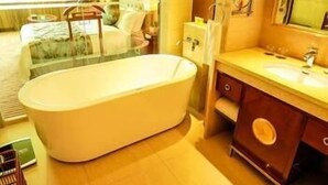 A modern bathroom with a freestanding bathtub, a vanity with a mirror, and a glass shower enclosure. - Heyuan City Holiday Hotel (Heyuan)