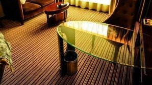 A hotel room with a sofa, armchair, and a glass-top table. - Heyuan City Holiday Hotel (Heyuan)