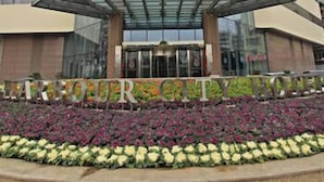 A hotel with a modern design, featuring a prominent entrance and a sign that reads "HARBOURCITY". - Harbour City Hotel (Jingmen)