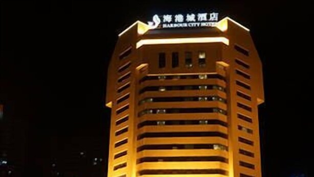 A multi-story hotel with a modern design, featuring a prominent sign at the top. - Harbour City Hotel (Jingmen)