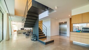 Ein modernes Interieur mit Treppe, einer Küchenzeile und einer Sitzecke.