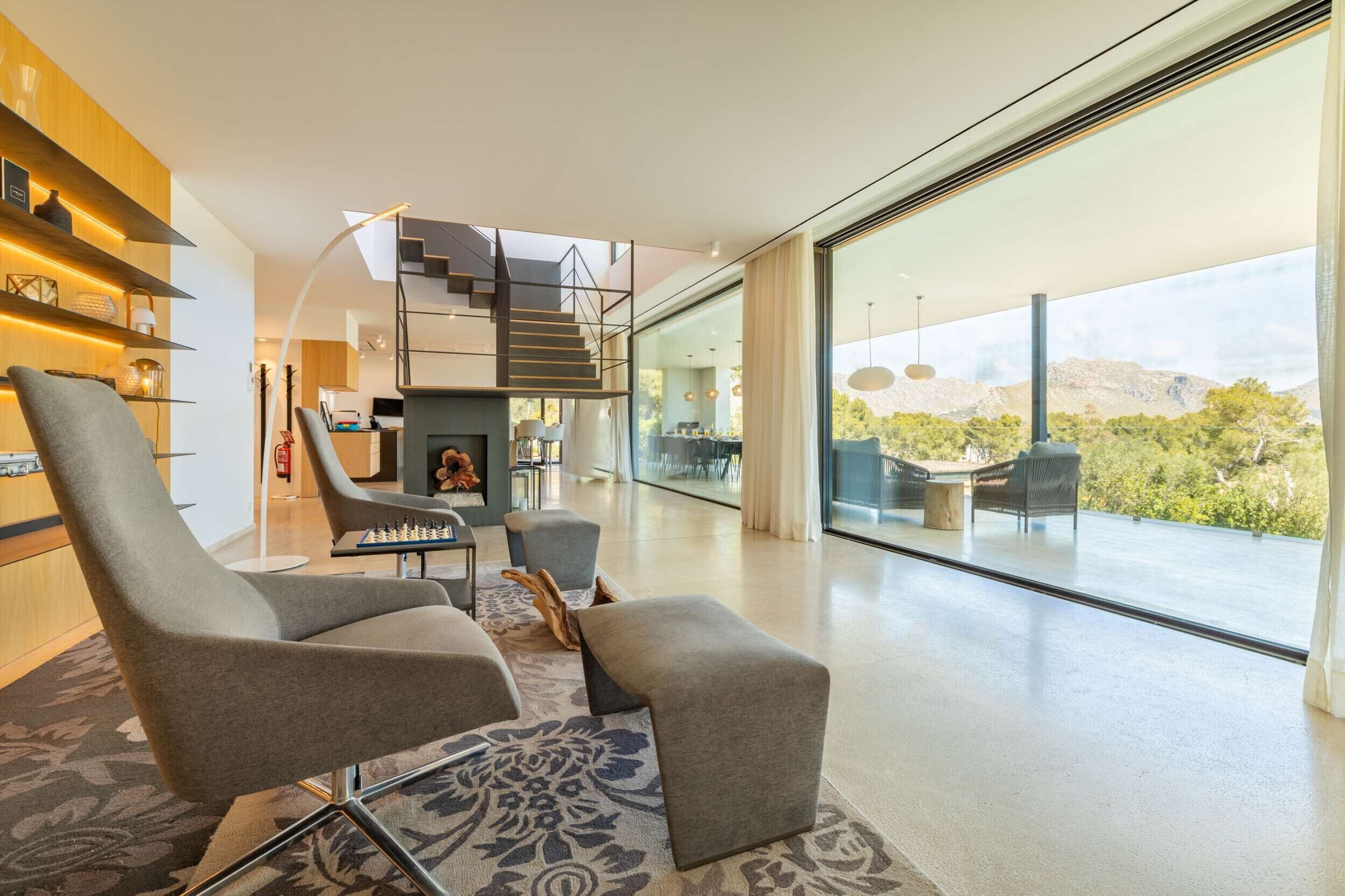 A modern living room with a fireplace, comfortable seating, and a staircase leading to an upper level.